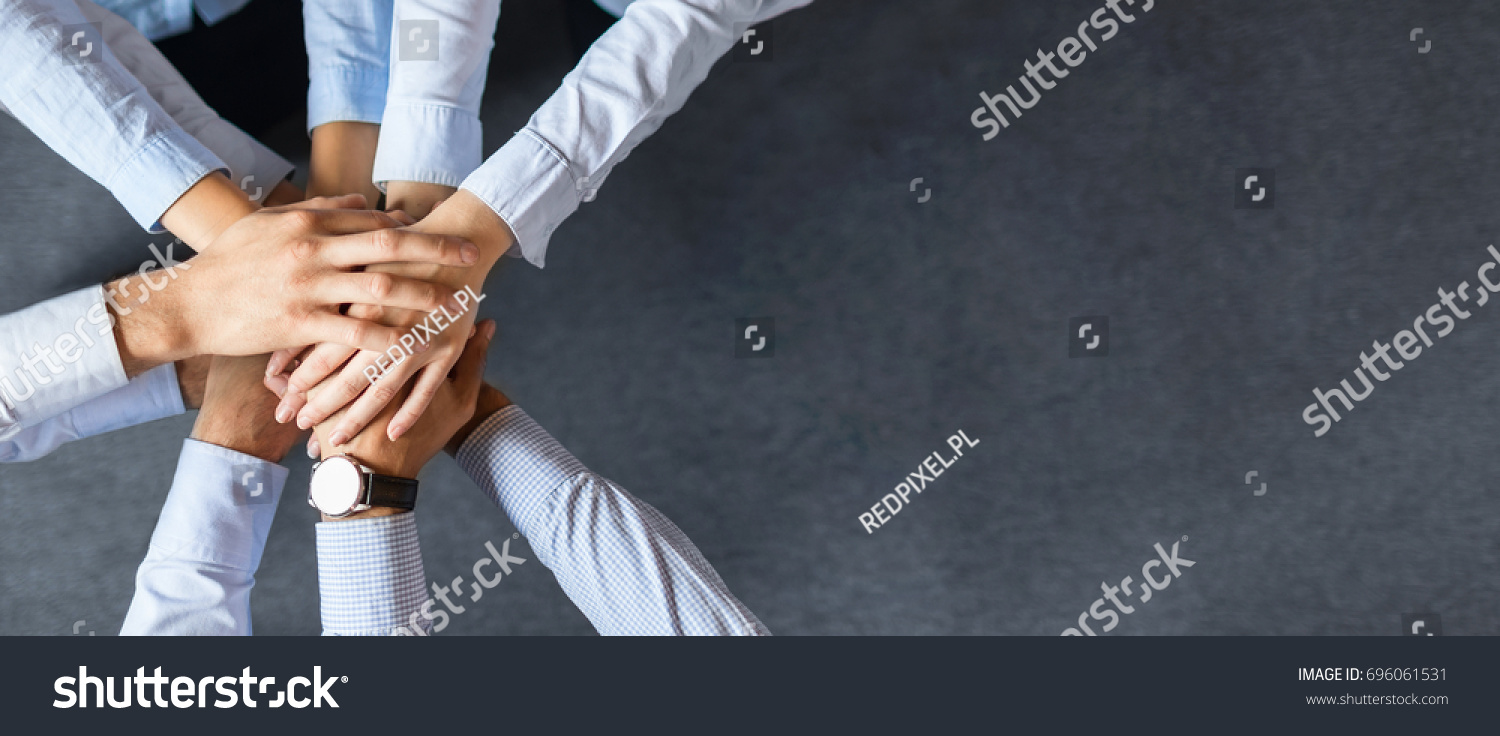 stock-photo-close-up-top-view-of-young-business-people-putting-their-hands-together-stack-of-hands-unity-and-696061531